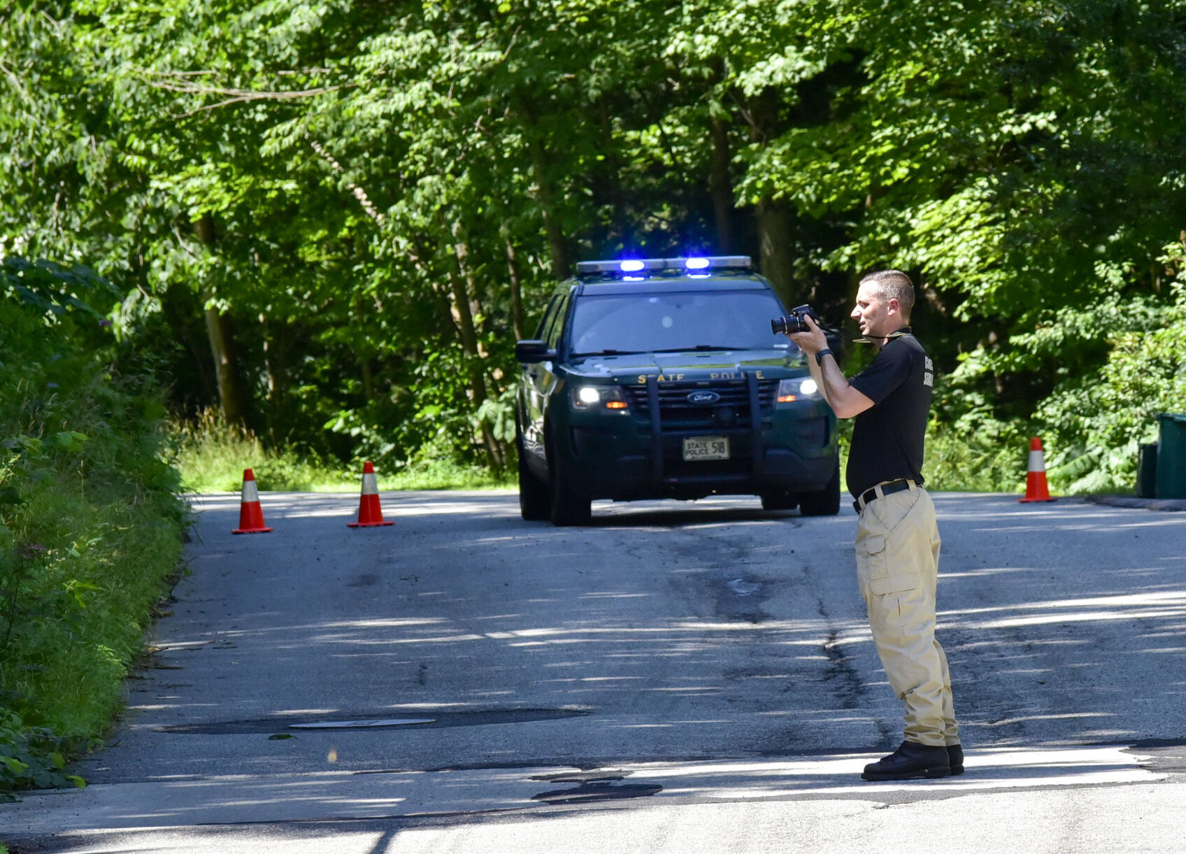 Investigator in road with police car in background (copy)